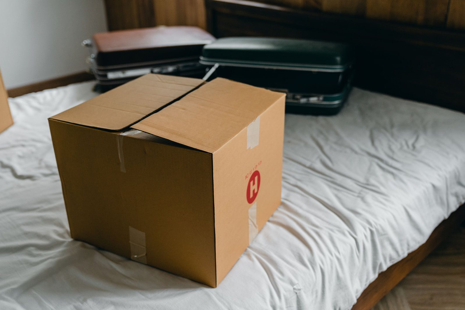 A packed box and suitcase on a bed, ready for a student move